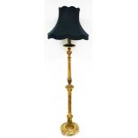 A heavily carved giltwood lamp standard, with turquoise shade on turned stem and circular base, term
