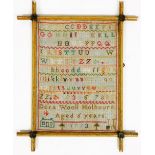 A late 19thC wool work alphabet sampler, by Dora Wool Holbourn aged 6 years, dated 1893, in a gilt w