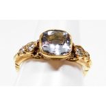 An 18ct gold aquamarine and diamond dress ring, with central old cut aquamarine in rub over setting,