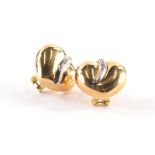 A pair of heart shaped and diamond set earrings, each polished gold design with central line of thre