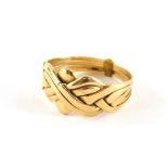 An interlinked dress ring, comprising five bands joined to make a knot design, yellow metal stamped