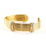 An 18ct gold bangle, with three row bar design, each set with a round brilliant cut diamonds, in cla