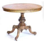 A Victorian walnut loo table, of oval form with quarter veneered top, on heavily carved stem, termin
