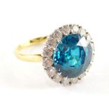 A blue zircon and diamond cluster ring, with central blue zircon totalling 13.1cts, within a border