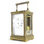 An early 20thC brass carriage clock, the back plate with Roman numeric dial, in a five part glazed c