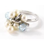 An 18ct white gold pearl diamond and blue topaz set dress ring, with cluster design of two pale blue