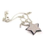 A Wempe diamond and black diamond star pendant and chain, with central rotating star centrally set w