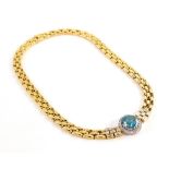 A blue zircon and diamond set necklace, with three row brick link necklets in yellow gold centre by