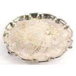 An Elizabeth II silver salver, with pie crust edge on triple scroll feet, partially engraved for the