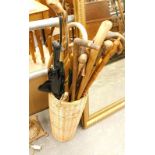 Various walking sticks in a wicker stick stand.