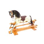 A Haddon Rockers rocking horse, the dappled horse with a maroon leather seat, on a pine base with Ha