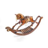 A 19thC style wooden rocking horse, with platted mane, and brass button ends, 81cm high, 143cm wide,