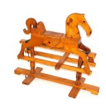A pine rocking horse, with tan leather saddle, 90cm high, 95cm wide, 34cm deep.