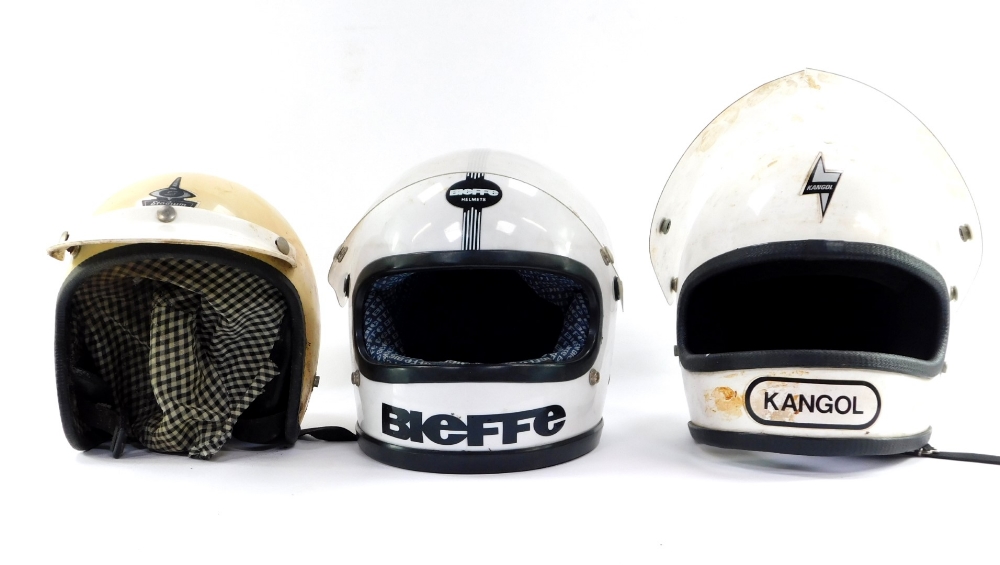 Three motorcycle helmets, comprising a Kangol white helmet, a BFE Bieffe helmets white crash helmet