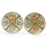 A pair of 19thC Chinese Canton porcelain plates, decorated in enamels with figures and flowers in sh