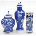Chinese blue and white porcelain, being two prunus decorated baluster vases and covers, (1 associate