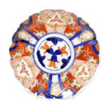 An early 20thC Japanese Imari charger, with flowers and rabbits, blue and white painted rim, 21cm di