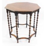 An early 20thC octagonal oak occasional table, raised on barley twist supports united by shaped