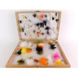 A wooden reservoir trout fly case, of two hinged sections and including a selection of reservoir