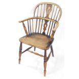 A 19thC oak and elm Windsor chair, with a carved shaped splat, solid saddle seat, raised on turned