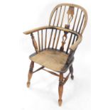 A 19thC oak and elm Windsor chair, with a carved shaped splat, solid saddle seat, raised on turned