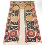 An Eastern inspired wall hanging, with threaded outer red border and detailing of flowers on brown g