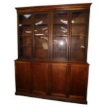 A Victorian mahogany library bookcase, the out swept pediment over two pairs of glazed doors, each