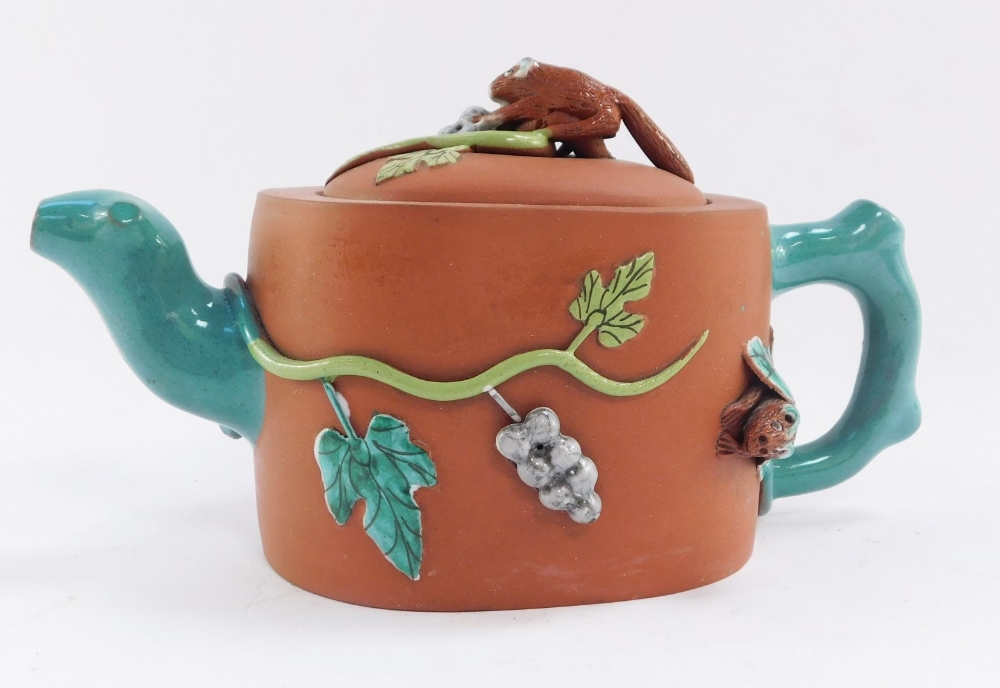 A Chinese redware teapot, with animal finial, carrying berries on vines and a bat, with turquoise ha