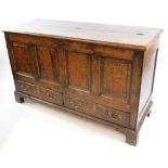 An 18thC oak mule chest, the hinged lid opening to reveal a candle tray above a pair of frieze