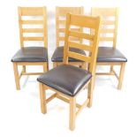 A set of four light oak ladder back single dining chairs, with over stuffed leather seats.