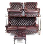A maroon leather button back Chesterfield sofa suite, comprising three seater sofa, two matching arm