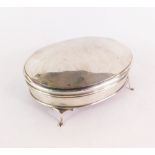 A George V silver dressing table box and cover, of oval form, monogram engraved, with a red velvet