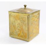 An early 20thC hammered brass tea canister, of square section with floral detailing, lift lid, on bu