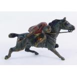 A cold painted bronze figure of a jockey on horseback, 5cm wide.