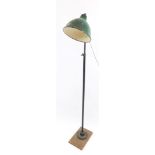 An industrial mid century anglepoise type standard lamp, the domed green metal shade, on iron circul