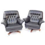 A pair of G-Plan mid century black vinyl swivel chairs, each on a wooden base with castors, with but