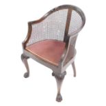 A Georgian style mahogany Bergere chair, early 20thC, with cane back and overstuffed seat, raised on