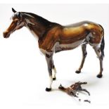 A Beswick Pottery figure of a brown gloss horse, 28cm high, and a foal, 12cm high. (both AF)