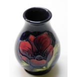 A Moorcroft pottery Anemone vase, of baluster form, against a blue ground, impressed marks, 10cm hig