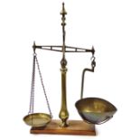 A set of Delarge brass scales, with two pans on octagonal baluster shaped column and hardwood base,