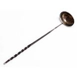 A Georgian toddy ladle, the bowl inset with a George II coin, with a whale bone twisted stem handle,