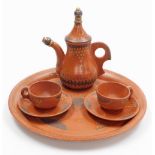A Turkish terracotta part tea set, decorated in gilt and dark brown, comprising circular tray, teapo