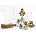 An early 20thC brass oil lamp base, 27cm high, various glass chimneys, glass oil lamp bases, etc. (a