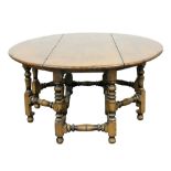 A Jacobean style solid oak and elm wake dining table, with double turned gate leg action, united by