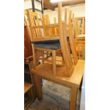 A light oak drawer leaf dining table, 79cm high, and four associated lath back chairs, with blue uph