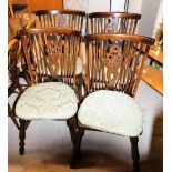 A set of four wheel and stick back dining chairs, with loose padded seats. The upholstery in this lo