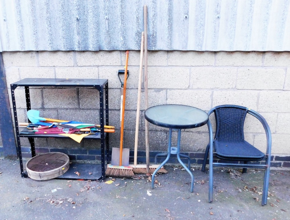 A garden table and two chairs, the table with a tempered glass top, various umbrellas, garden brushe