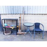 A garden table and two chairs, the table with a tempered glass top, various umbrellas, garden brushe