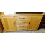 A modern light oak sideboard, with four drawers flanked by two hinged cabinets, 79cm high, 150cm wid