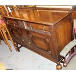 An early 20thC oak sideboard, the top with two drawers above two hinged cabinets, 98cm high, 135cm w